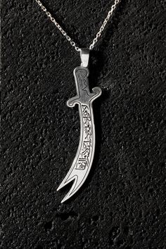 Embrace a piece of history and valor with the Zulfiqar Sword Pendant Necklace, featuring the powerful inscription: "There is No Sword Except Zulfiqar, There is No Brave Except Ali." This striking necklace showcases a detailed Zulfiqar sword design, a symbol of courage and righteousness. Crafted from high-quality sterling silver, the pendant captures the iconic double-edged sword with meticulous craftsmanship, reflecting its historical and symbolic significance. The inscription on the pendant pays homage to Ali ibn Abi Talib, renowned for his bravery and the legendary Zulfiqar sword. The detailed engraving adds a personal touch, making it a meaningful accessory for those who admire historical symbols of heroism. Whether you're looking for a unique piece of jewelry or a thoughtful gift that Stylish Gifts, Sterling Silver Jewelry, Brave, Thoughtful Gifts, Jewelry Necklace Pendant, Silver Jewelry, Jewelry Necklaces, Accessory Gift, 925 Sterling Silver