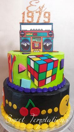 a multi - layered cake decorated with rubik cubes and numbers