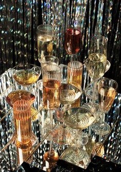 a table topped with lots of glasses filled with different types of liquid and drinks on top of each other