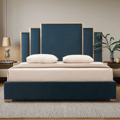 a bed with blue headboard and pillows in a room