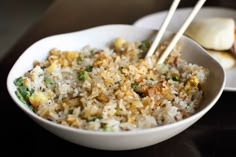 a white bowl filled with rice and vegetables