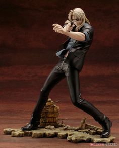 the action figure is dressed in black and has his hands up to his face as he stands