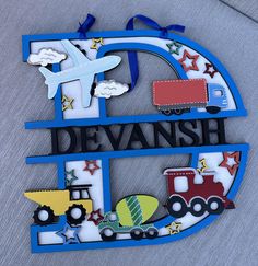 a wooden sign with a train, truck and plane on it that says devansh