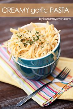 a blue bowl filled with pasta on top of a wooden table