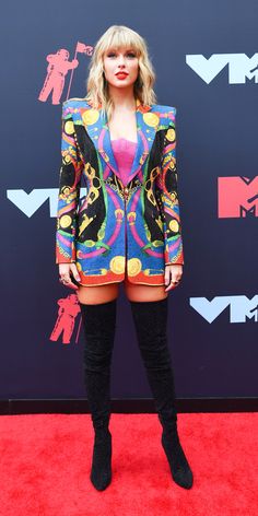 taylor swift at the vmas red carpet wearing a colorful suit and thigh high boots