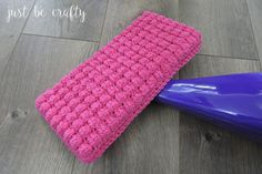 a pink crochet net mop pad sitting next to a blue plastic blow dryer