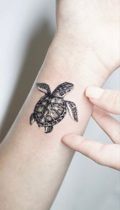 a small turtle tattoo on the wrist