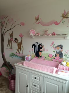 a baby's room decorated in pink and white with animals on the wall, crib