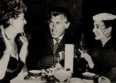 an old black and white photo of three people sitting at a table