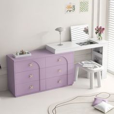 a white and purple dresser sitting next to a window