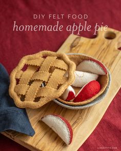 a homemade apple pie sitting on top of a wooden cutting board next to a red cloth