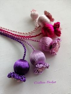 three balls of yarn sitting on top of a white cloth covered table next to each other