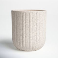 a white vase sitting on top of a table