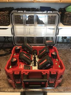 a red tool box filled with tools on top of a counter