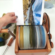 a person is weaving fabric on a spinning wheel with scissors and yarn in the background