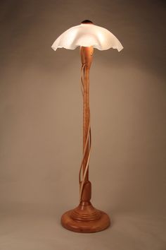 a wooden lamp with a white shade on it's base and a cord wrapped around the bulb