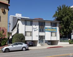 an apartment building with cars parked in front