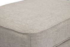 a close up view of the back end of a grey ottoman cushion with buttons on it