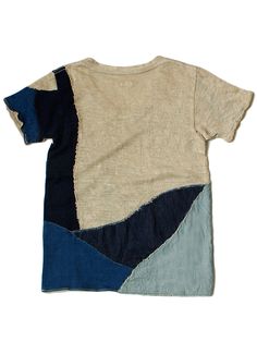 a t - shirt with blue, beige and black patches on the front is shown