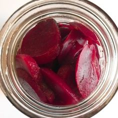 a jar filled with beets sitting on top of a table