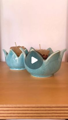 two blue ceramic bowls sitting on top of a wooden table