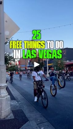 a man riding a bike down a street next to a tall white pole with the words 25 free things to do in las vegas