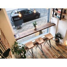 an overhead view of a coffee shop with wooden tables and benches in front of the window