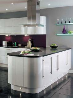 a modern kitchen with white cabinets and black counter tops, along with an island in the middle