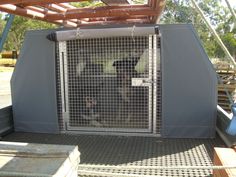 an animal cage in the back of a truck with metal bars on it's sides