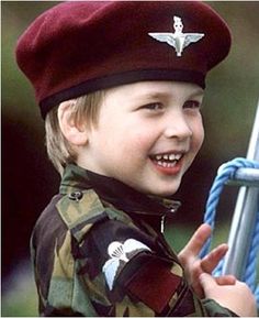 a young boy wearing a pilot's cap and smiling