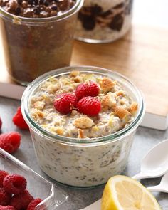 two bowls of oatmeal with raspberries and granola on the side