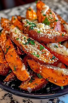 a plate full of cooked carrots with parmesan cheese and herbs on top