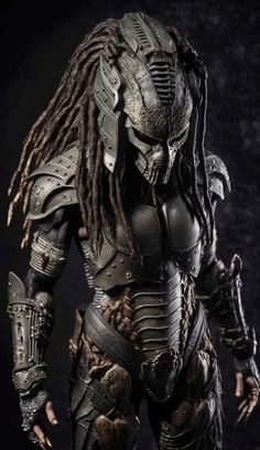 the predator figure is shown in full armor and dreadlocks, with his hands on his hips