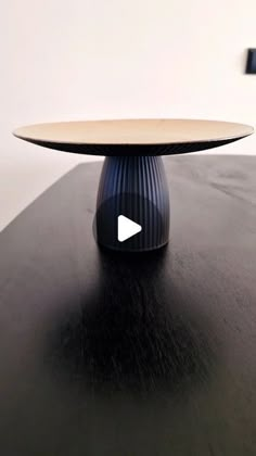 a black table with a wooden top and an arrow in the center that says youtube