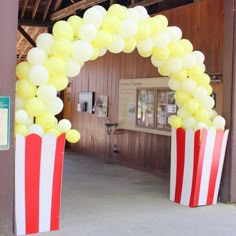 an arch made out of popcorn buckets with balloons attached to the top and bottom