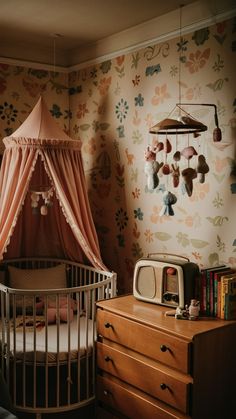 a baby's room with a crib, dresser and wallpaper