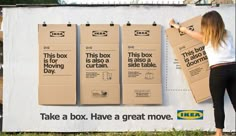 a woman placing boxes on the side of a moving box sign that says take a box have a great move