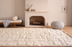 a living room with a white rug and fireplace