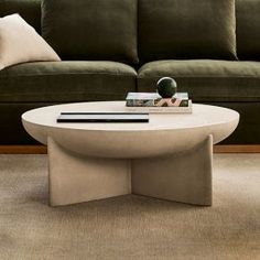 a living room with a couch, coffee table and books on the end tables in front of it