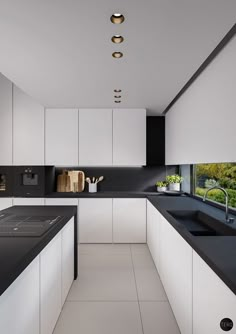 a modern kitchen with black counter tops and white cabinetry is pictured in this image