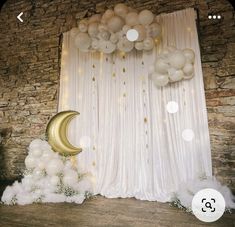 an image of a balloon arch and moon on the stage for a birthday party or baby's first birthday