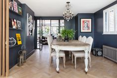 a dining room with blue walls and wooden floors