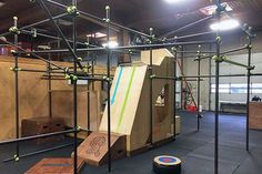 an indoor play area with climbing ropes and obstacles