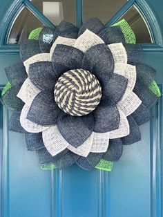 a blue front door with a black and white burlocked flower on it