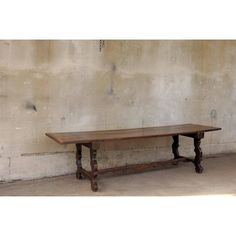 an old wooden table sitting in front of a wall