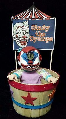 a toy clown sitting in a bucket with a sign on it's head that says,