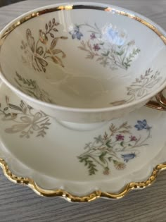 two cups and saucers sitting on top of a wooden table next to each other