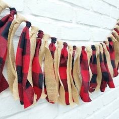 a red and black plaid scarf hanging on a white brick wall