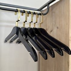 several black and gold clothes hangers on a wooden door