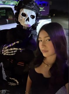 a woman standing next to a skeleton statue